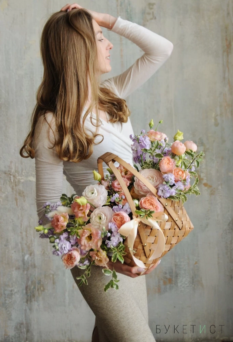 Воздушный букет ранункулюсов, садовых роз и сезонных цветов в корзине