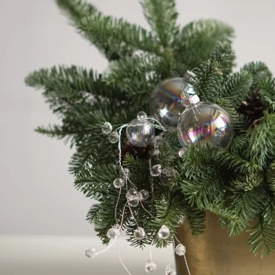 Композиция из живой ели с бусами и свечами в металлическом горшочке