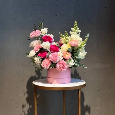 Авторская композиция в шляпной коробке с ранункулюсами