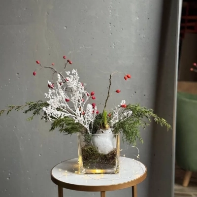 Новогодняя композиция с заснеженными ветками и луковицей амариллиса