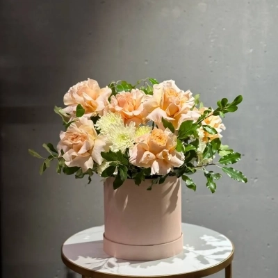 Авторская композиция в шляпной коробке с гвоздиками и аспарагусом