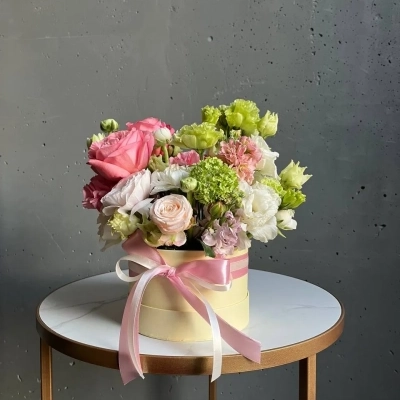 Композиция в шляпной коробке "Клубничный лайм" с ранункулюсами и вибурнумом