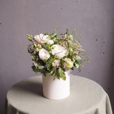 Воздушная композиция с ранункулюсами в шляпной коробке